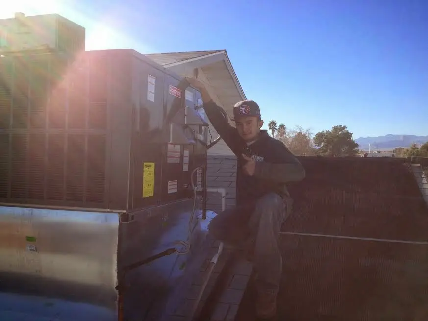 HVAC technician performing AC Tune-Up on a rooftop unit in Middleburg Heights